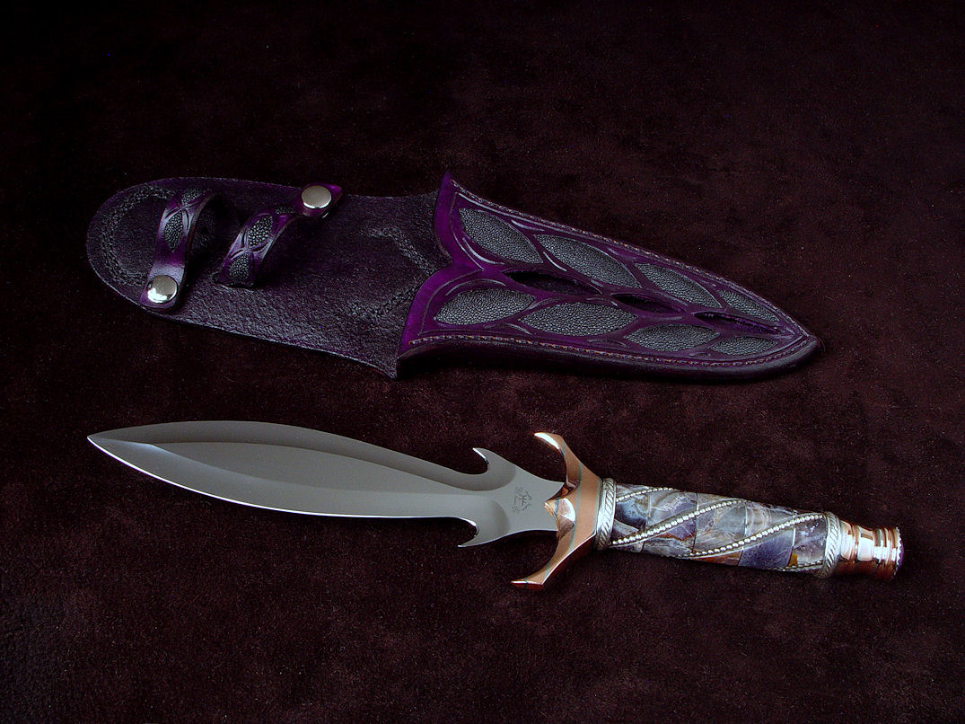 "Amethistine" dagger, obverse side view in 440C high chromium stainless steel blade, diffusion welded copper, nickel silver fittings, sterling silver gallery wire wrap and accents, Amethyst crystal gemstone pommel, hand-carved leather sheath inlaid with black rayskin